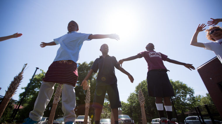 kids outside with arms spread out