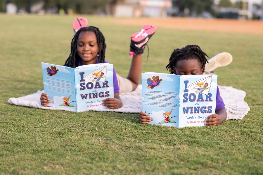 Two kids reading on a blanket