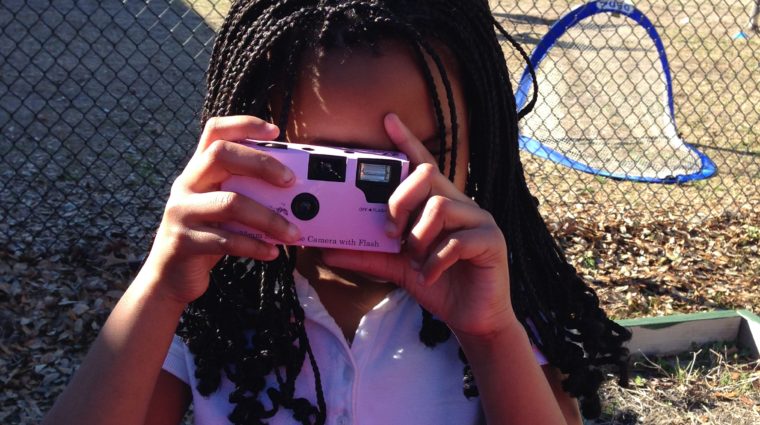 girl looking through a camera