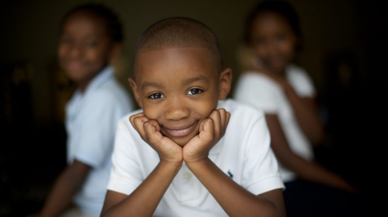 school children lined up in front of brick wall