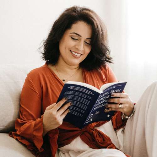 An adult woman sits comfortably reading a book