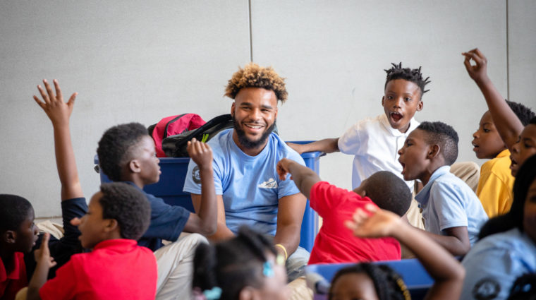 Volunteer surrounded by happy children